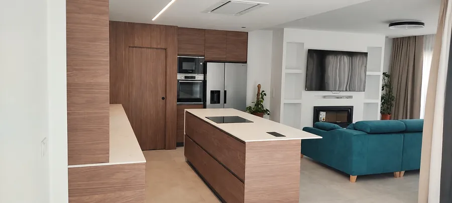 Küche in Nussbaum mit weißer Kochinsel, offen zum Wohnzimmer